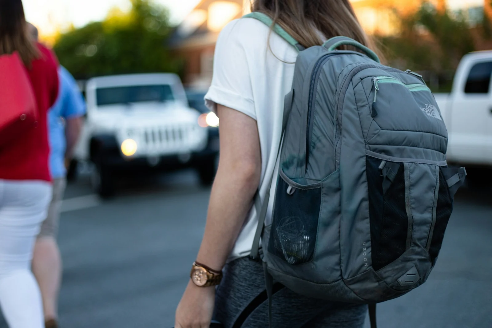 Sac à dos gris porté dans la rue, avec ses bretelles et ses poches visibles