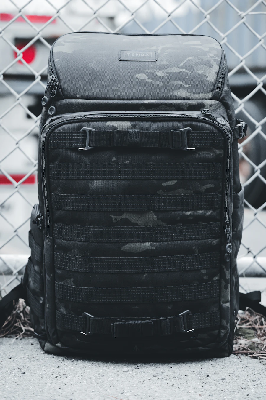 Sac à dos sombre vu de face et entièrement visible, avec ses poches et fermetures