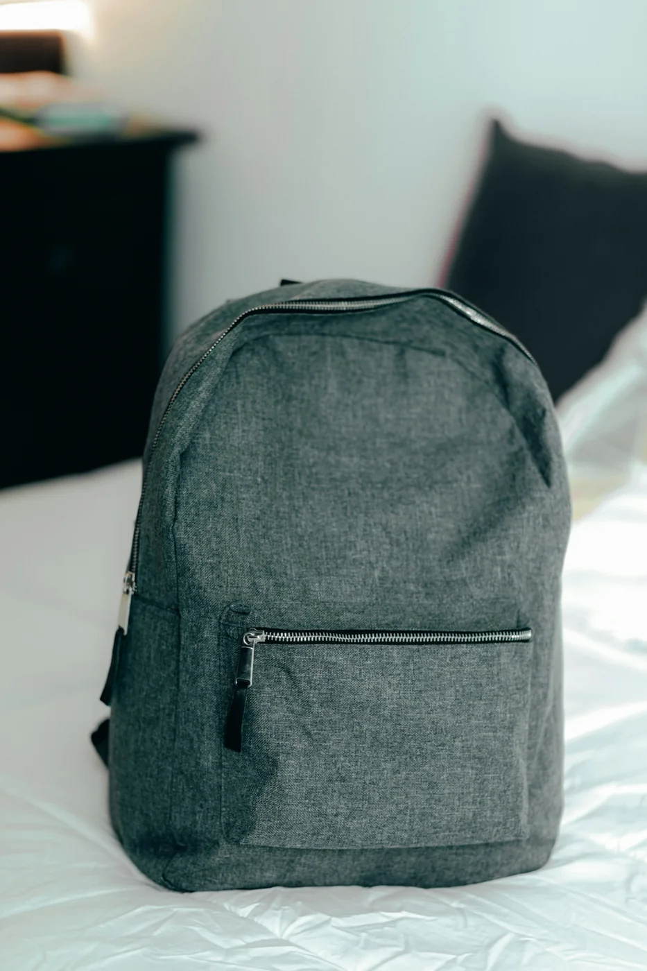 Un sac à dos compact posé sur un lit