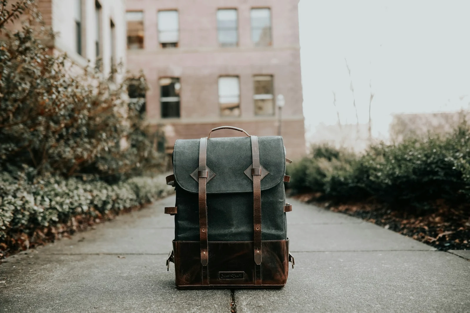 Sac à dos souple rectangulaire posé sur un trottoir ; photo illustrative, dimensions non attestées