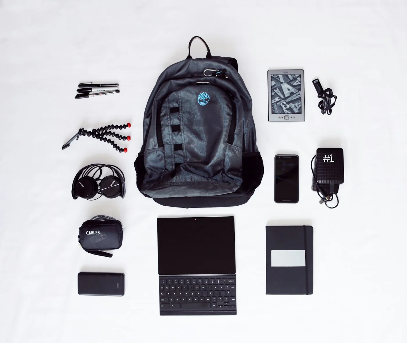 Sac, ordinateur et accessoires disposés à plat, hors sélection