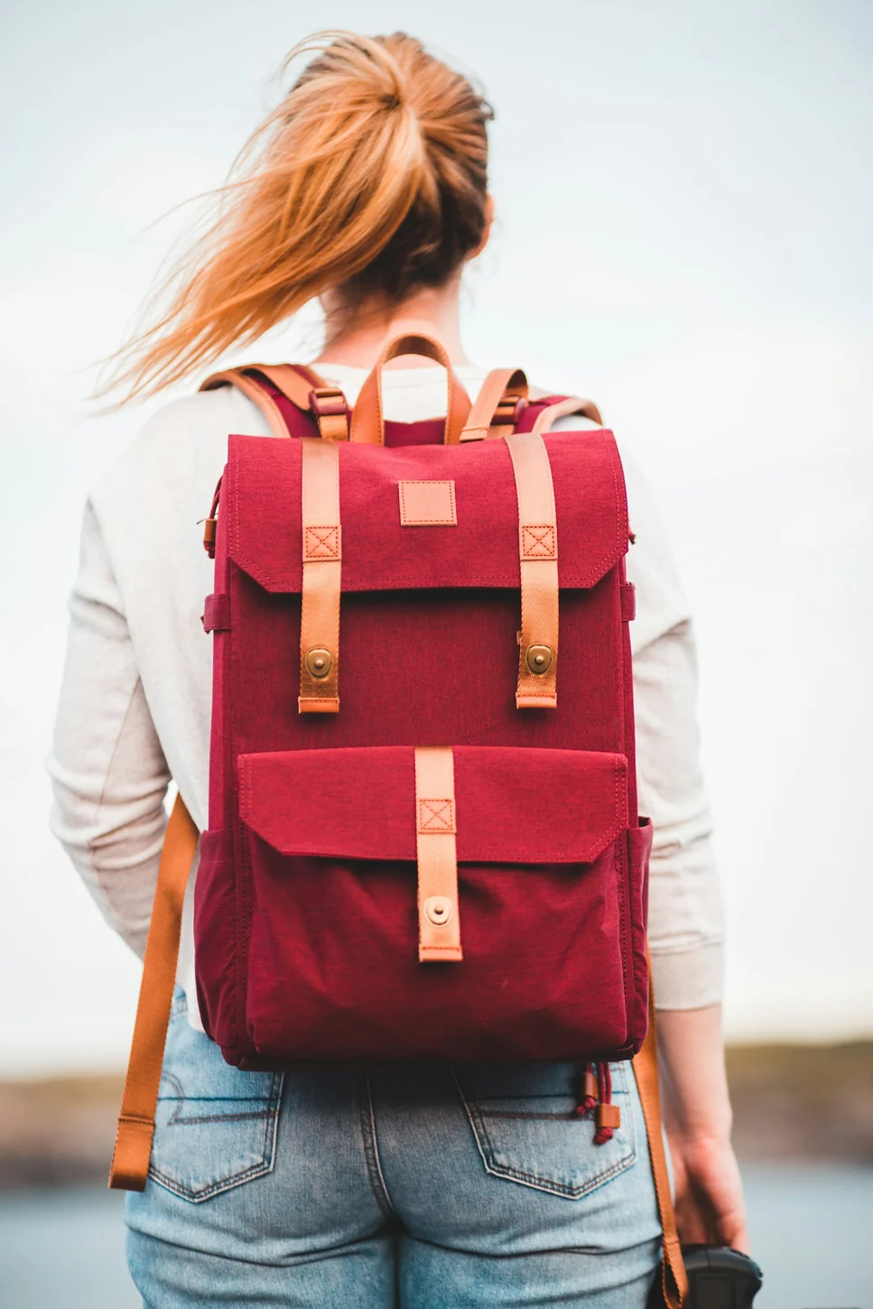 Petit sac à dos rouge porté sur les épaules pendant un déplacement